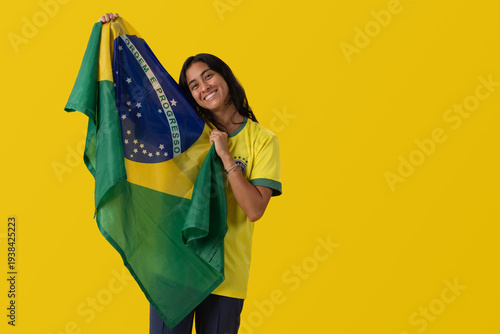Happy Brazilian female soccer fan celebrating World Cup 2026 victory on yellow background.