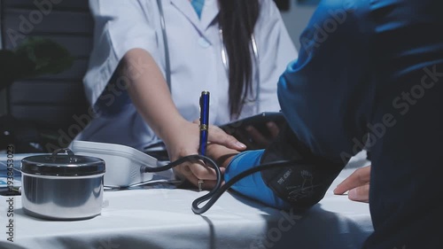Doctor using stethoscope take a tap on the patient's arm and pressing pressure gauge button.