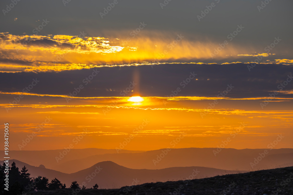 Obraz premium Golden sun setting over layered mountains in Navarra, Spain