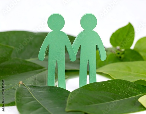 Two green cutout figures stand holding hands amongst vibrant green leaves on a white background