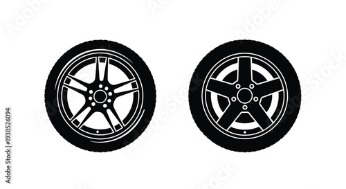 Two black car wheels with detailed rims a stark silhouette