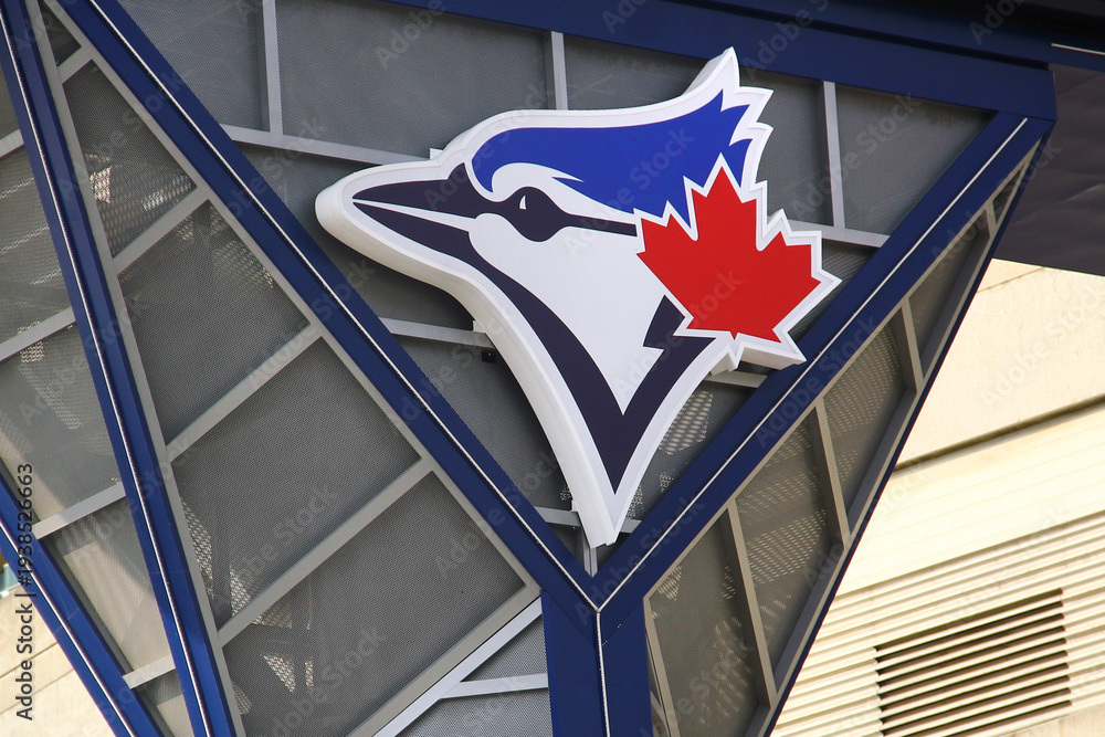 Fototapeta premium Toronto, Canada - February 15, 2026: Toronto Blue Jays logo with blue jay and red maple leaf mounted on Rogers Centre stadium facade in downtown Toronto