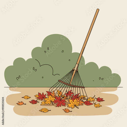A rake gathering a pile of colorful autumn leaves on the ground with green bushes in the background, illustrating a fall yard chore.