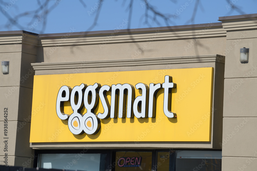 Fototapeta premium bright yellow sign of Eggsmart, a breakfast restaurant chain, located here at 312 O'Connor Dr, Toronto