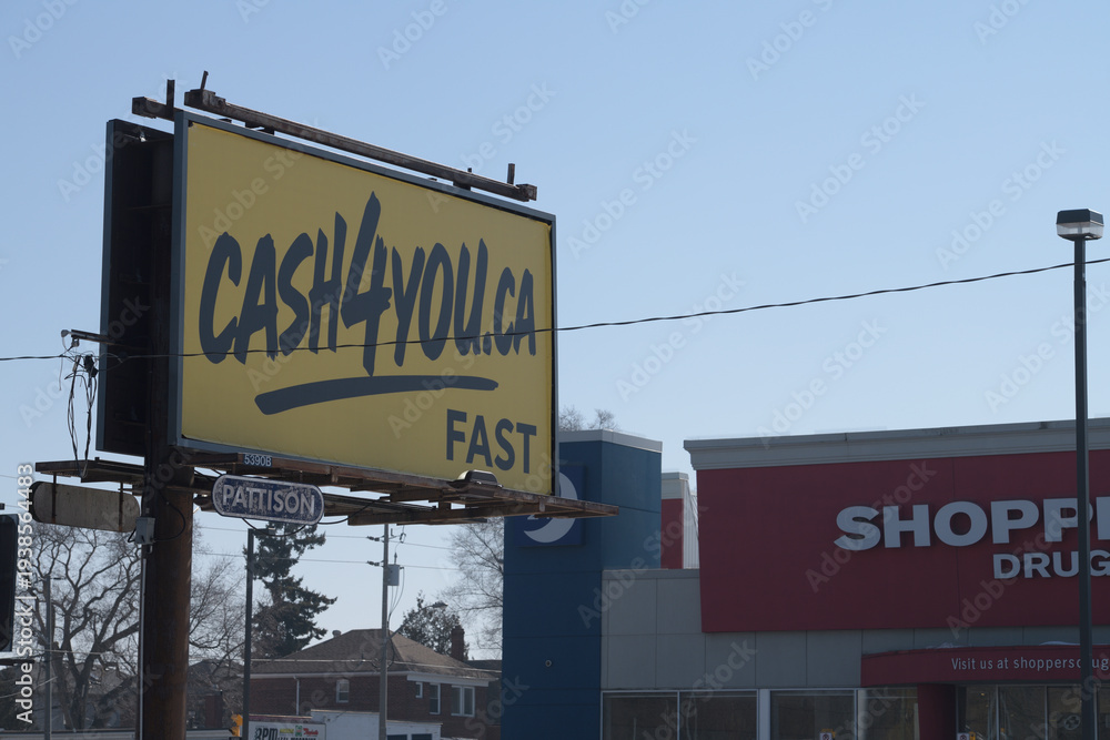 Fototapeta premium traditional roadside billboard with cash4you advertisement and defocused Shoppers Drug Mart location at southwest corner of O'Connor Dr and Woodbine Av, Toronto