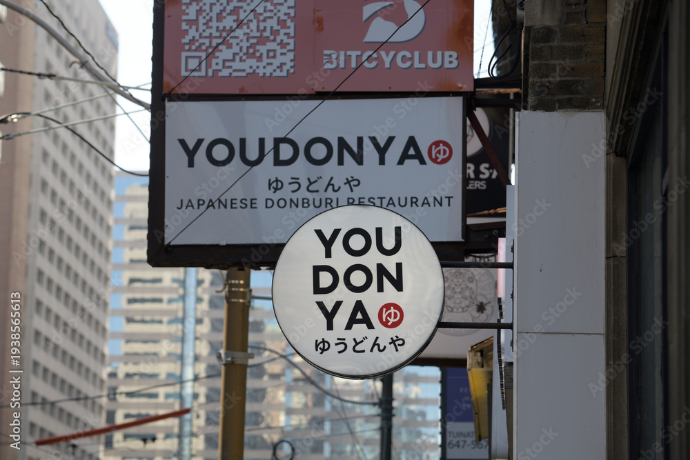Fototapeta premium wall mounted round projecting sign outside YOU DON YA, a Japanese restaurant, located at 108 Dundas St W, Toronto