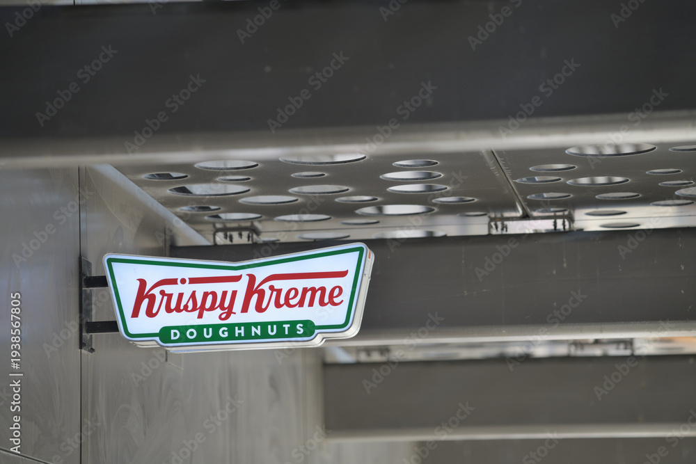 Fototapeta premium wall mounted illuminated logo sign of Krispy Kreme Café, a donut shop chain, located here at 105 Dundas St E, Toronto