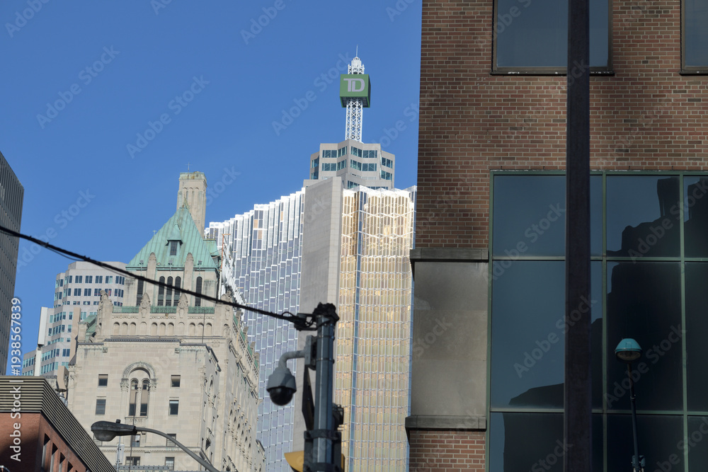 Fototapeta premium contrast of architecture styles: Fairmont Royal York hotel, RBC Royal Bank Plaza, South Tower, and beacon with corporate logo sign on top of TD Canada Trust Tower, Toronto