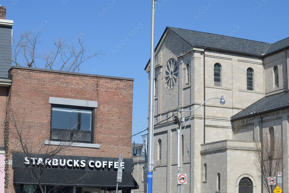 Fototapeta premium exterior building facade and sign of Starbucks Coffee Company located here at 604 Danforth Av, corner of Gough Av (next to Holy Name Parish), Toronto