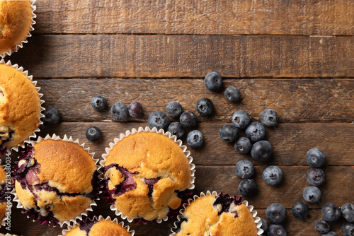Homemade Blueberry Muffins and Fresh Blueberries on Dark Rustic Wooden Table with Copy Space