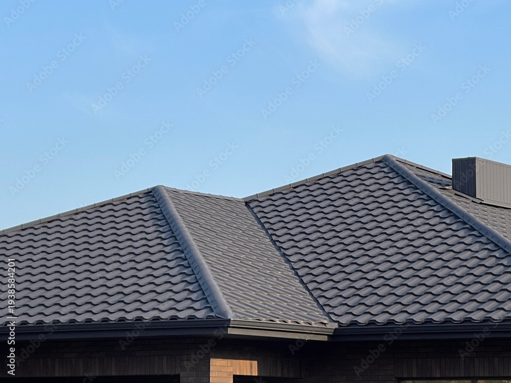 Fototapeta premium Roof and Tiles Shown Against Clear Sky, Illustrating the Design and Structure of a Building's Upper Section in Daylight