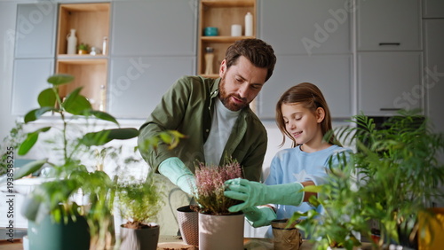 Man daughter planting plants in pots caring natural green home decor closeup.