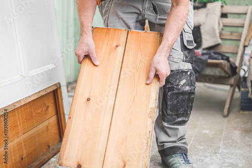 Wallpaper Mural One young worker holds wooden planks from the door. Torontodigital.ca