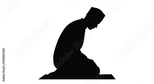 Silhouette of a muslim man kneeling in prayer on a rug