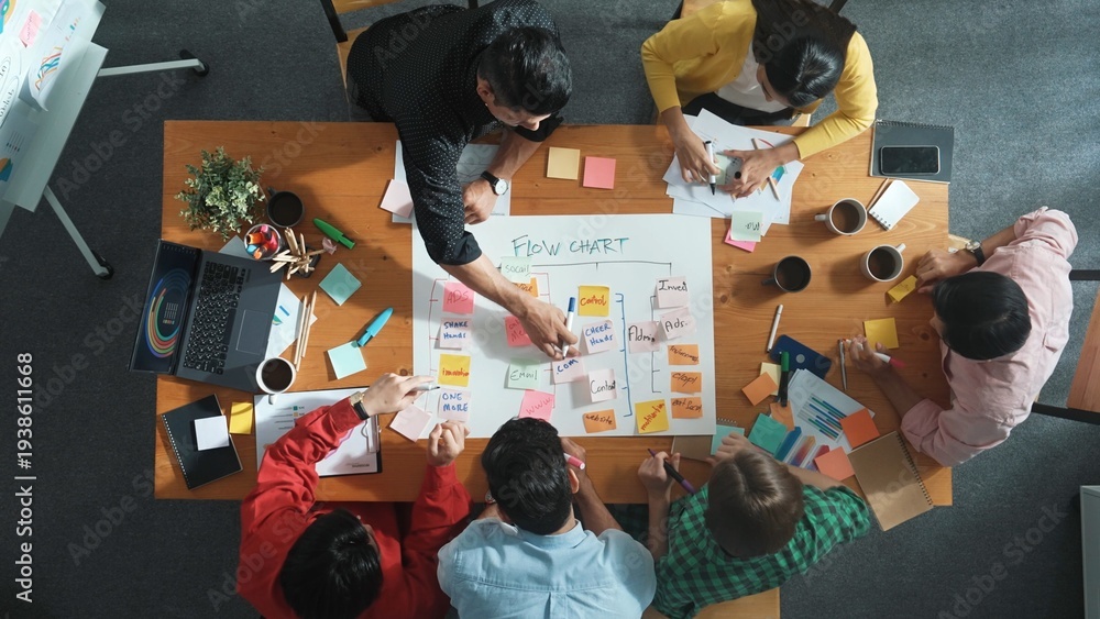 Obraz premium Top down aerial view of professional business people hands making scrum task board to manage workflow in workplace. Diverse marketing team writing and working together at meeting room. Convocation.
