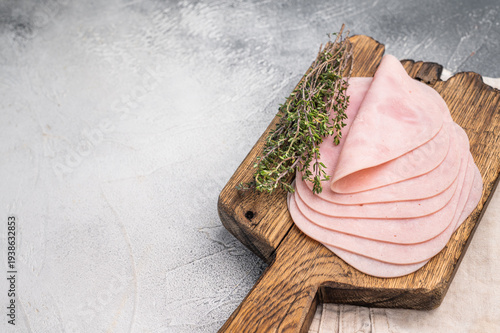 Delicious slices of cured ham on a wooden platter, ideal for entertaining and adding flavor to your dishes. white background. top view