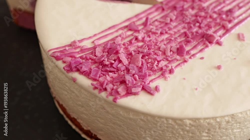 Wallpaper Mural A frosted cake sits on a black plate. It features white icing, diagonal pink drizzle, and bright pink sprinkles. Torontodigital.ca
