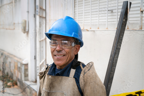 Foto Smiling construction worker wearing hard hat and safety glasses