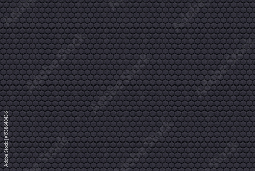 A close-up view of a seamless black hexagonal pattern texture. This dark, monochromatic honeycomb design features a rough, rubber-like surface, making it ideal for use as an industrial background, tec