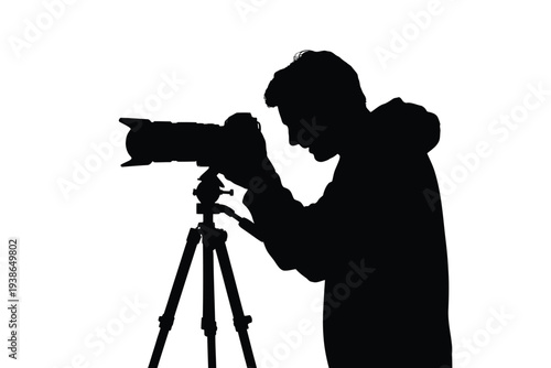 Silhouette of a photographer using a camera on a tripod