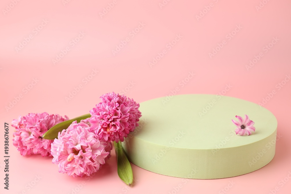 Fototapeta premium Empty podium and spring flowers on pink background, closeup. Mockup for design
