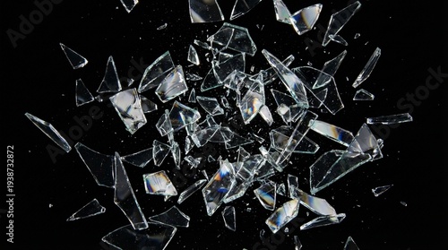 Foto Sharp shards of broken glass exploding and flying through the air, isolated on a black background
