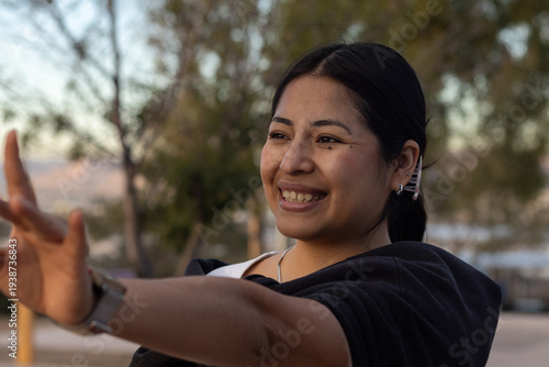 Obraz na plátne Young hispanic woman smiling brightly and reaching out, expressing joy and optim