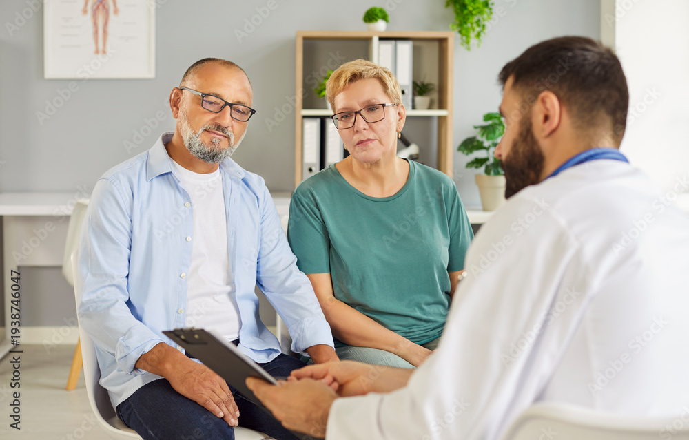 Obraz premium Senior couple meets with their doctor in a clinic for medical consultation to review symptoms, medications and care options and treatment. Elderly patients talking with physician during exam
