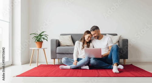Young couple sitting on red carpet with laptop in a modern living room setting