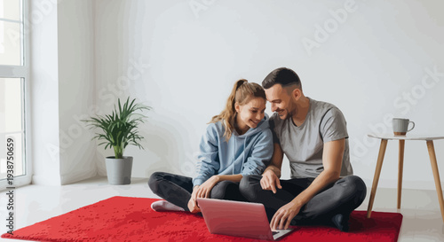 Young Couple Sitting on Red Carpet Using Laptop Together