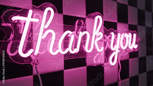 Bright Pink Neon Thank You Sign Glowing Against Black and White Checkerboard Wall.