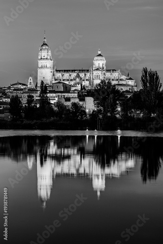 Salamanca, Castilla y Leon, Spain: Twilight view of the Cathedral of Salamanca illuminated and reflected in the waters of river Tormes; the Old Cathedral, Cathedral of Santa Maria in black and white