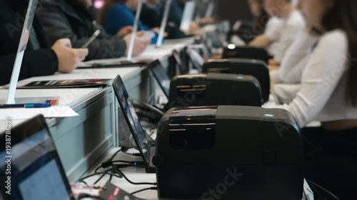 Conference registration desk where staff check in participants and print badges during corporate business event or professional seminar.
