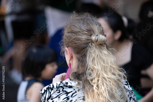 Принти на полотні Golden-blonde-haired woman with tied-up hair walking in outdoor market, hair and skin texture, rear view, at Chatuchak Market