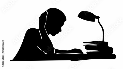 Focused student studying with books and lamp on desk