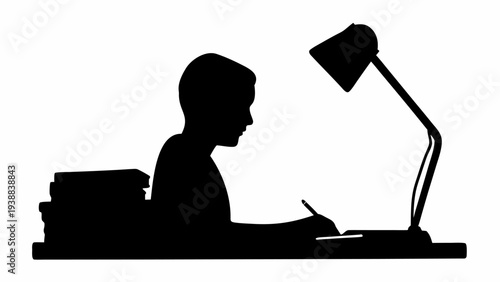 Focused student studying with desk lamp at night