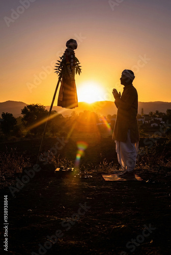 Indian man praying to Gudi during Gudi Padwa festival at sunset