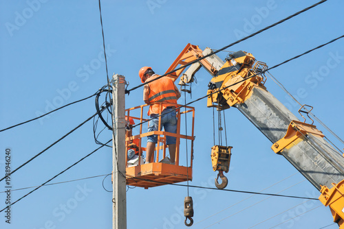 Electricians repairing power lines from an aerial lift platform