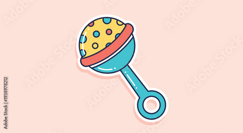 Colorful baby rattle toy with polka dot pattern on a soft pink background used for newborn entertainment and sensory development.