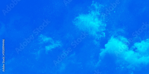 Deep vibrant blue abstract background with ethereal cyan ink splashes clouds and glowing light effects.