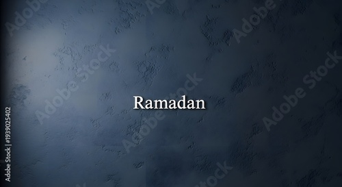 Elegant embossed text 'Ramadan' centered on a textured dark blue background with subtle lighting and shadows