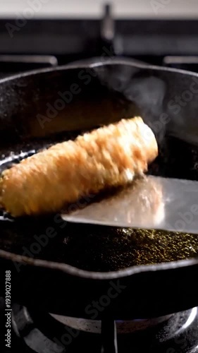 Burger patty cooking in hot oil on stove