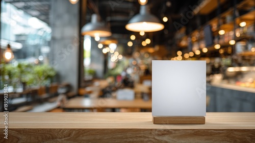 Mock-up of a blank menu label frame on a bar restaurant table, acrylic tent card stand with white sheets, blurred cafeteria background .