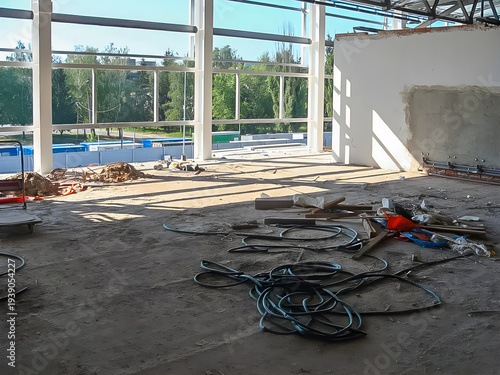 Interior of a building under construction with large windows and natural light