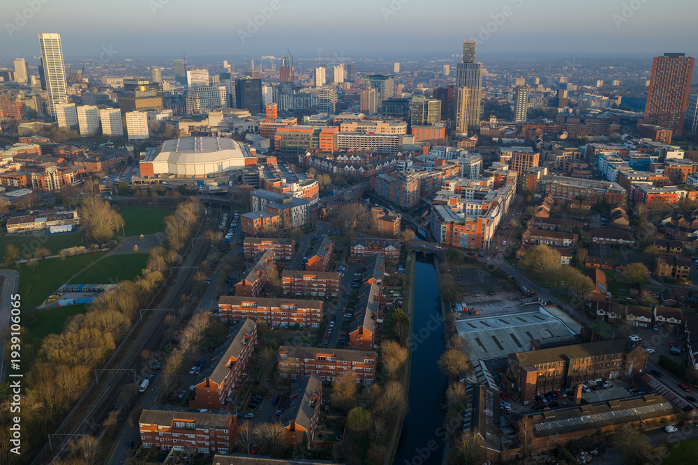 Obraz premium Aerial image of the Birmingham canal network and residential estates at dusk, featuring modern skyscrapers at Sunset. 