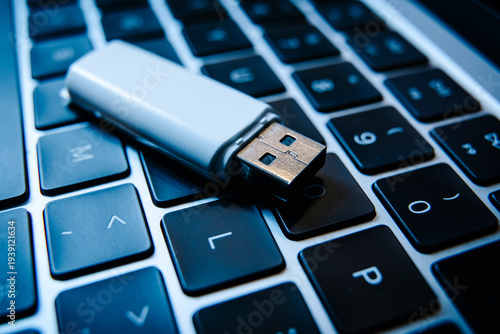 USB flash drive lying on a laptop keyboard as a concept of cyber security and digital data protection