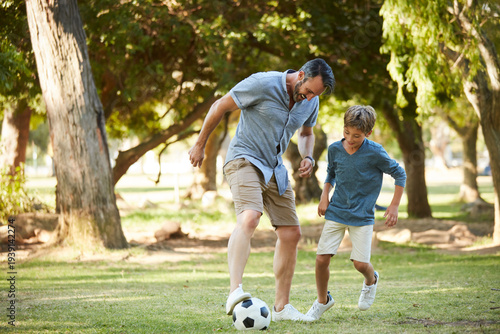 Fotografie Father, boy and play with football at park for bonding, exercise and fun with teaching, kick and outdoor in summer
