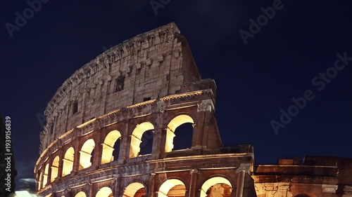 Time lapse shot of traffic on a city street in front of the illuminated Colosseum in Rome at dusk. Rome, Italy 4K