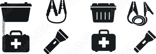 An essential emergency kit is displayed showcasing a first aid kit, jumper cables, a flashlight, and a storage container, highlighting key items for safety and preparedness in critical situations.