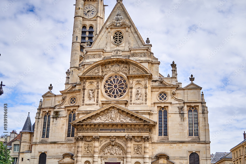 Fototapeta premium Facade of Église Saint-Étienne-du-Mont, a historic church in Paris Latin Quarter featuring Gothic and Renaissance architecture with ornate stone carvings, rose window, and clock tower